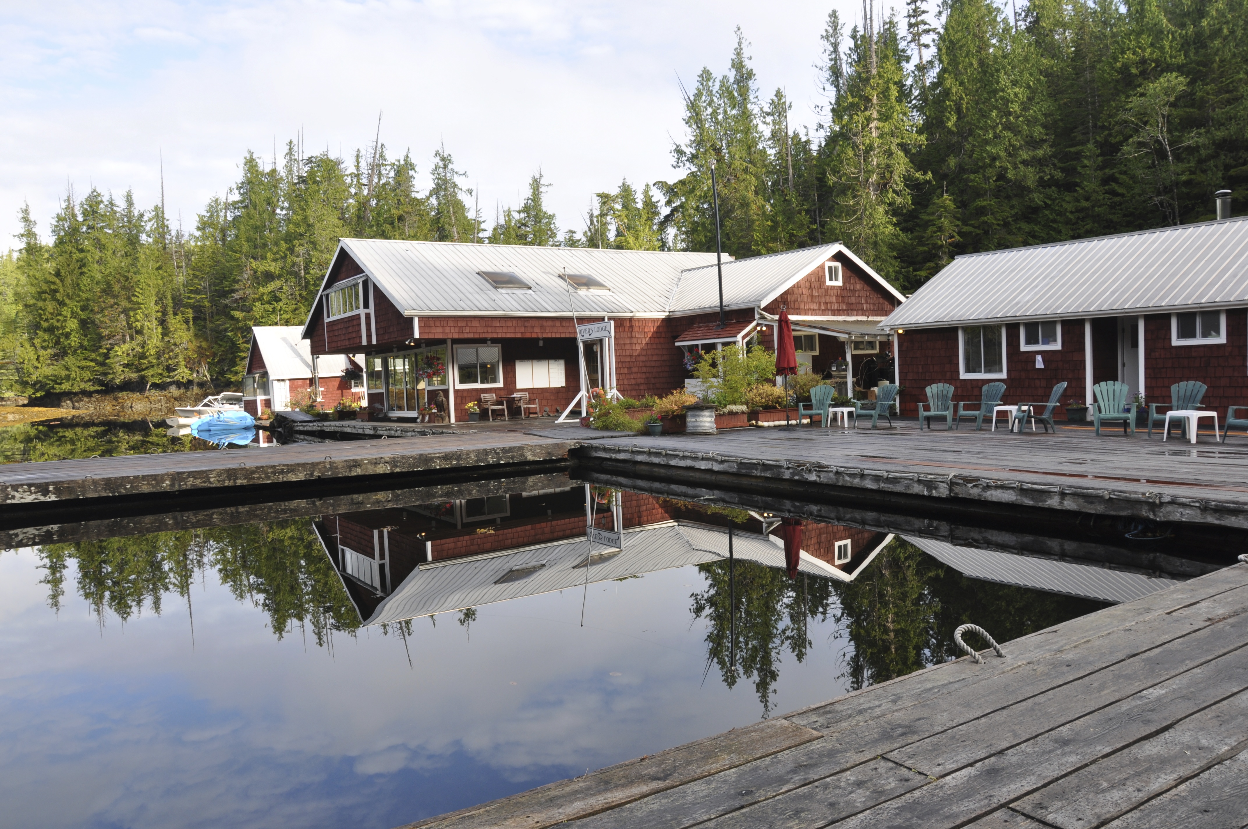 Red cedar lodge buildings along waterfront with boats